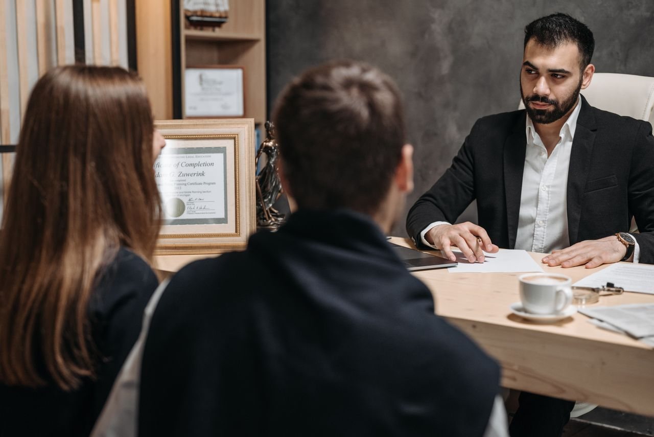A lawyer reviews documents with clients in an office